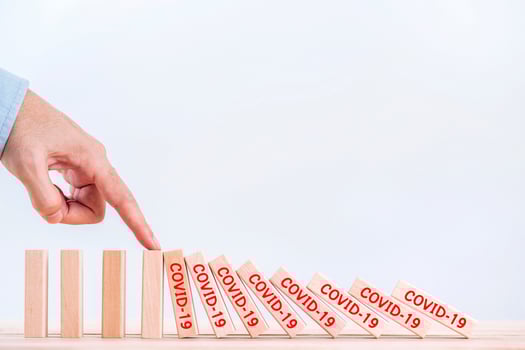Businessman hand stopping the domino represents pandemic COVID-19 virus effect  , Stop the spread of the coronavirus photo