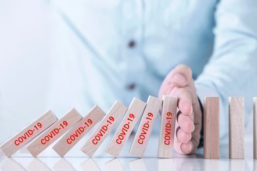 Businessman hand stopping the domino represents pandemic COVID-19 virus effect  , Stop the spread of the coronavirus photo