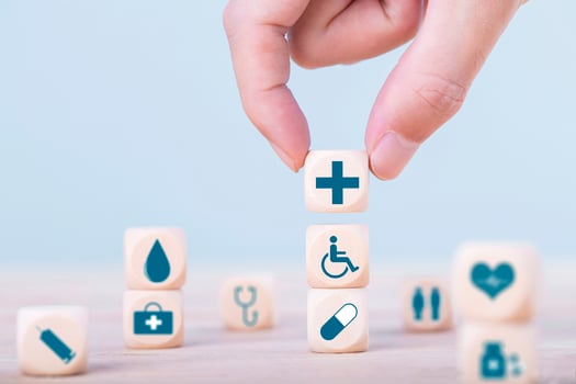 Hand chooses a emoticon icons healthcare medical symbol on wooden block , Healthcare and medical Insurance concept photo