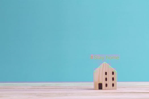 COVID-19 Coronavirus stay at home concept , mini wooden home with text hashtag STAY HOME on the blue background photo