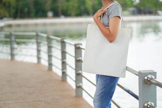 hipster woman holding white tote bag for mock up blank template photo