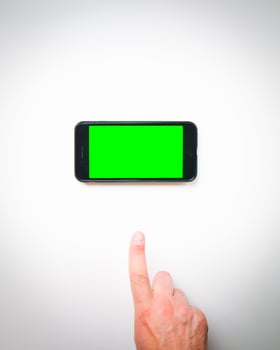Male hand finger up to smartphone green screen on a white background curtains. Isolated blank space copypaste smartphone background mock up photo