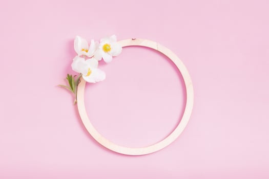 Summer or spring composition on a pink background. Wooden frame with anemone flowers with copy space. Summer, spring floral concept photo