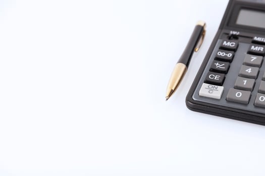 Black color calculator and yellow-black metal pen on a white backgroundFinancial activity, accounting, tax calculation or savings and investments. copy space. photo