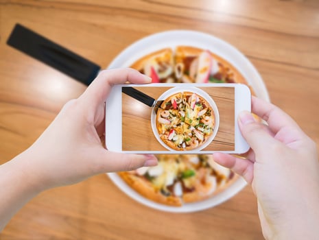 woman taking photo of Pizza with mobile smartphone