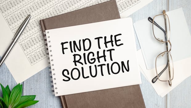 Find The Right Solution text on white notebook and pen on wooden background photo