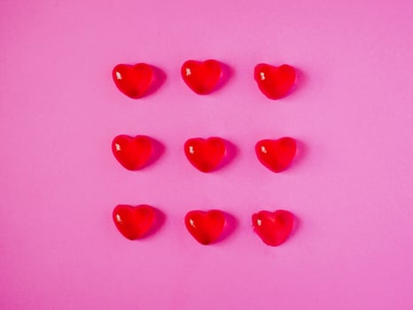 red valentine candy hearts shape on pink background photo