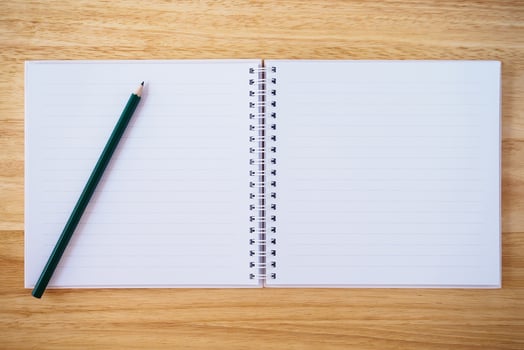 notebook top view with pencil on brown wood desk photo