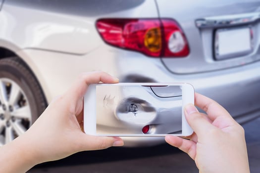 woman using mobile smartphone taking photo of car accident damaged for insurance