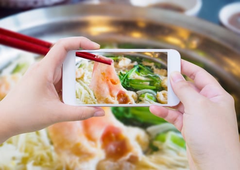 woman taking photo of sukiyaki shabu shabu