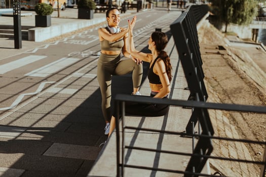Young women in sportswear exercising on a river promenade photo