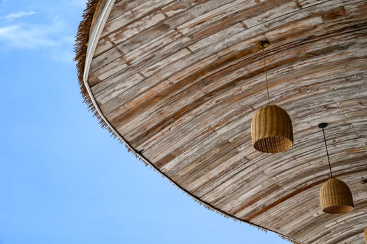 Wooden thatch roof with lamp hanging and sky photo