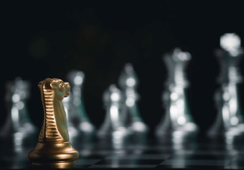 Golden knight chess pieces facing in front silver chess on board with flare light to successfully in the competition. Management or leadership strategy and teamwork concept. photo
