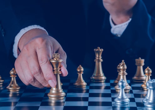Hand of businessman holding gold king chess on stock market or forex trading graph chart with cityscape image economy trend for digital financial investment.Management or leadership strategy concept. photo
