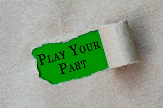 Play your part text on torn hole in the sheet of brown paper on green background photo