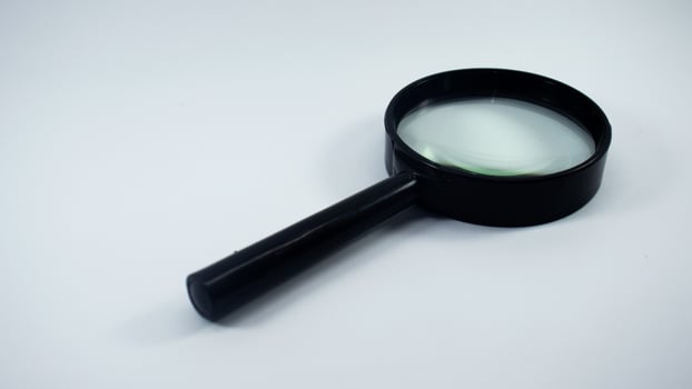Close up shot of a black magnifying glass on a white background. photo