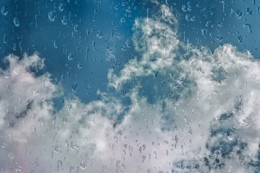 drops on the window and blue sky background photo