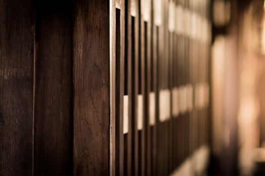 Shallow depth of field shot of wall of the ancient Thai wooden house and the evening sun light photo