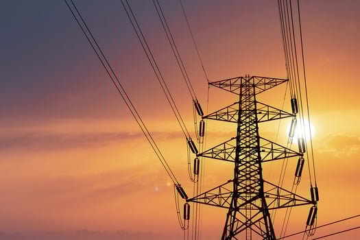Silhouette of high voltage poles with electric wires. Silhouette of high voltage power line cables in an orange evening sunset. Steel structure of electric poles. electric power transmission concept photo