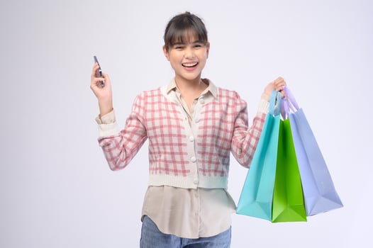 Attractive shopper woman holding shopping bags over white background photo