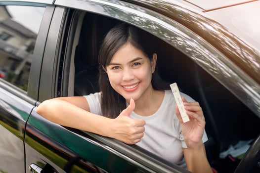 A woman holding atk in car, do a self-collection test for a COVID-19 test, health and safety photo