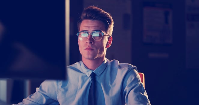 man working on computer in dark office photo