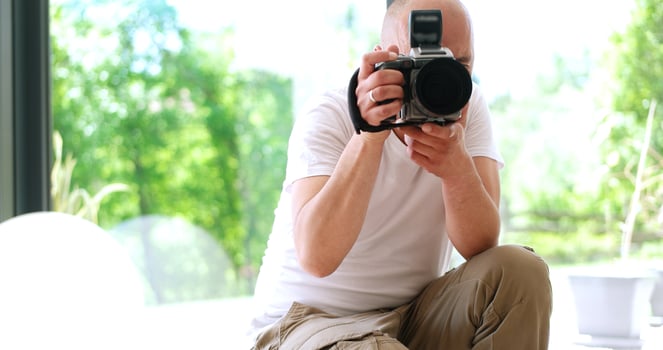 Photographer takes pictures with DSLR camera photo