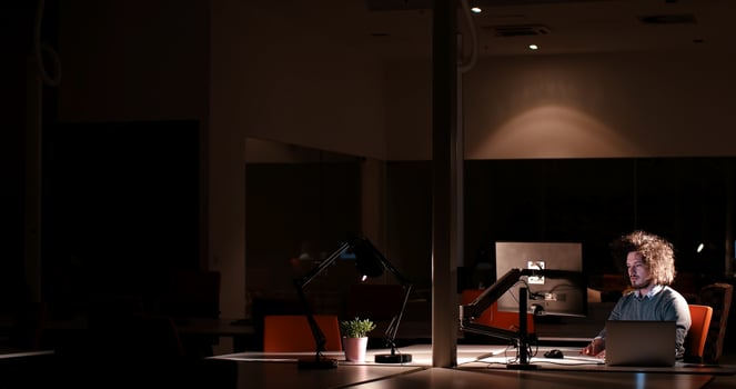 man working on computer in dark office photo