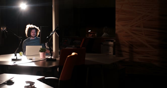 man working on computer in dark office photo