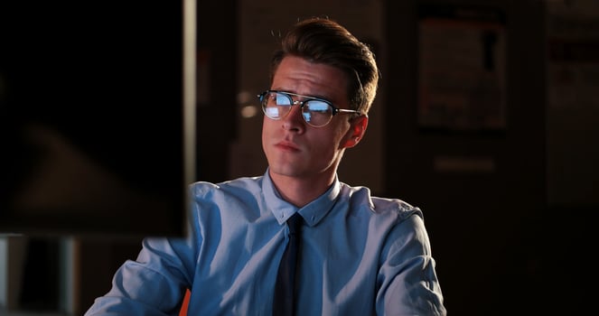 man working on computer in dark office photo