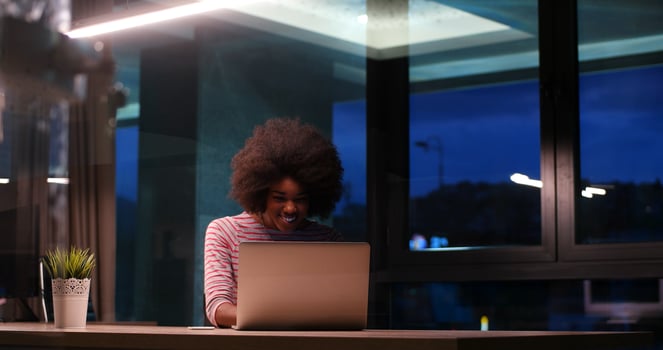 black businesswoman using a laptop in night startup office photo