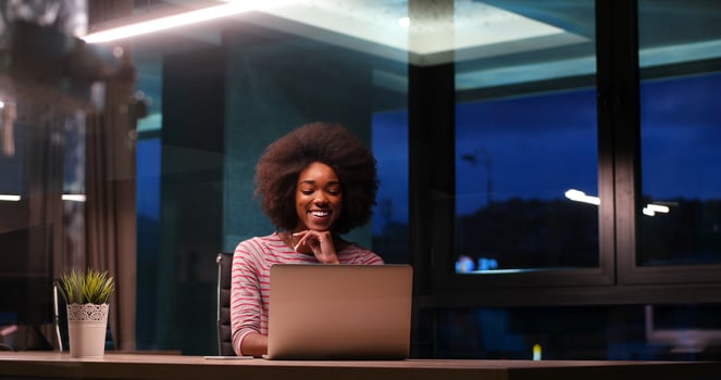 black businesswoman using a laptop in night startup office photo