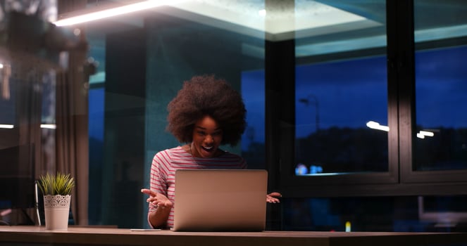 black businesswoman using a laptop in night startup office photo