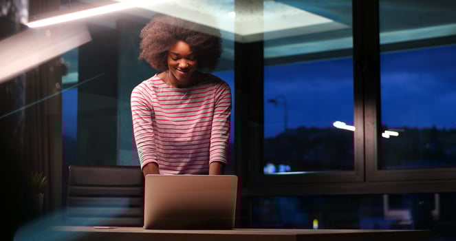 black businesswoman using a laptop in night startup office photo