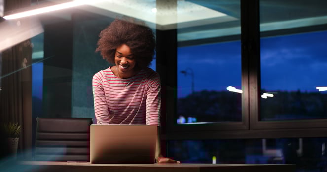 black businesswoman using a laptop in night startup office photo