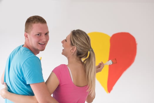 couple are painting a heart on the wall photo