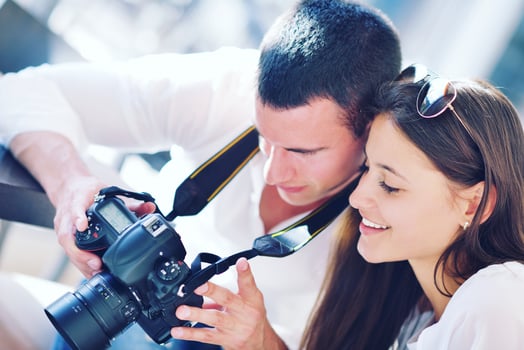 couple looking photos on camera
