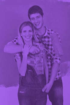 happy couple paint wall at new home photo