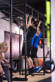 young athletes doing pull ups on the horizontal bar photo