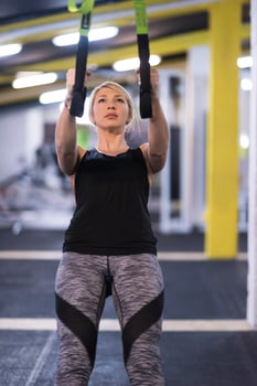 woman working out pull ups with gymnastic rings photo