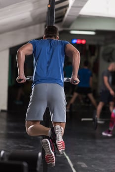 man doing exercises parallel bars photo