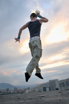 young man dancing and jumping  on top of the building photo