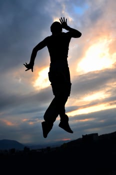 young man dancing and jumping  on top of the building photo