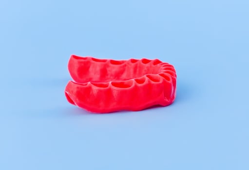 model of human gums without teeth isolated on blue photo
