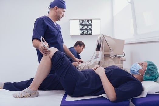 doctor working at the hospital operating ultrasound scanning machine examining knee of her female patient technology modern medicine people vitality concept. photo