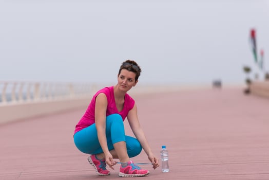 Young woman tying shoelaces on sneakers photo