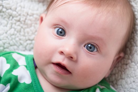 cute little baby playing with hands and smiling photo
