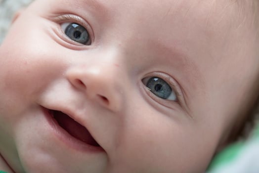 cute little baby playing with hands and smiling photo