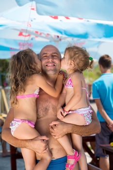 portrait of young happy father with daughters by the sea photo