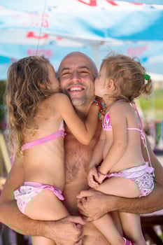 portrait of young happy father with daughters by the sea photo